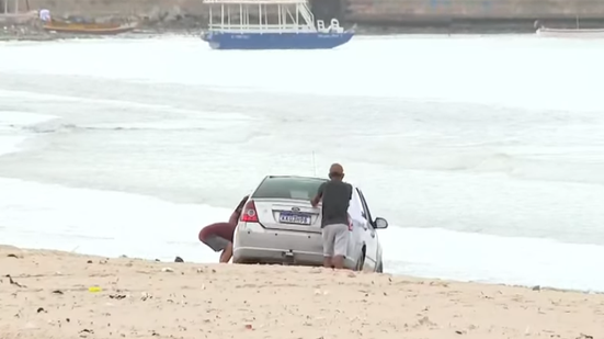 Carro atola após motorista invadir faixa de areia na Praia da Avenida, em Maceió